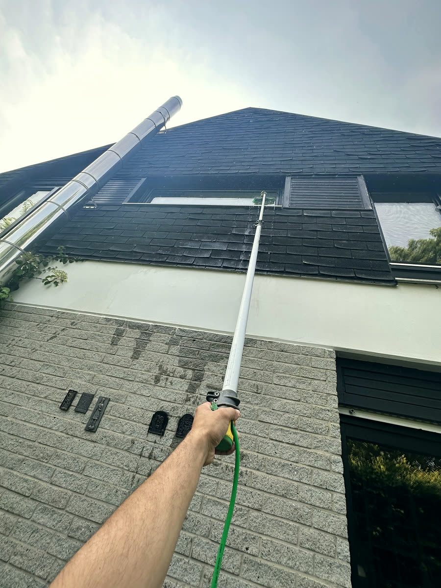 Glasreinigung mit Teleskopstange an einer Fassade